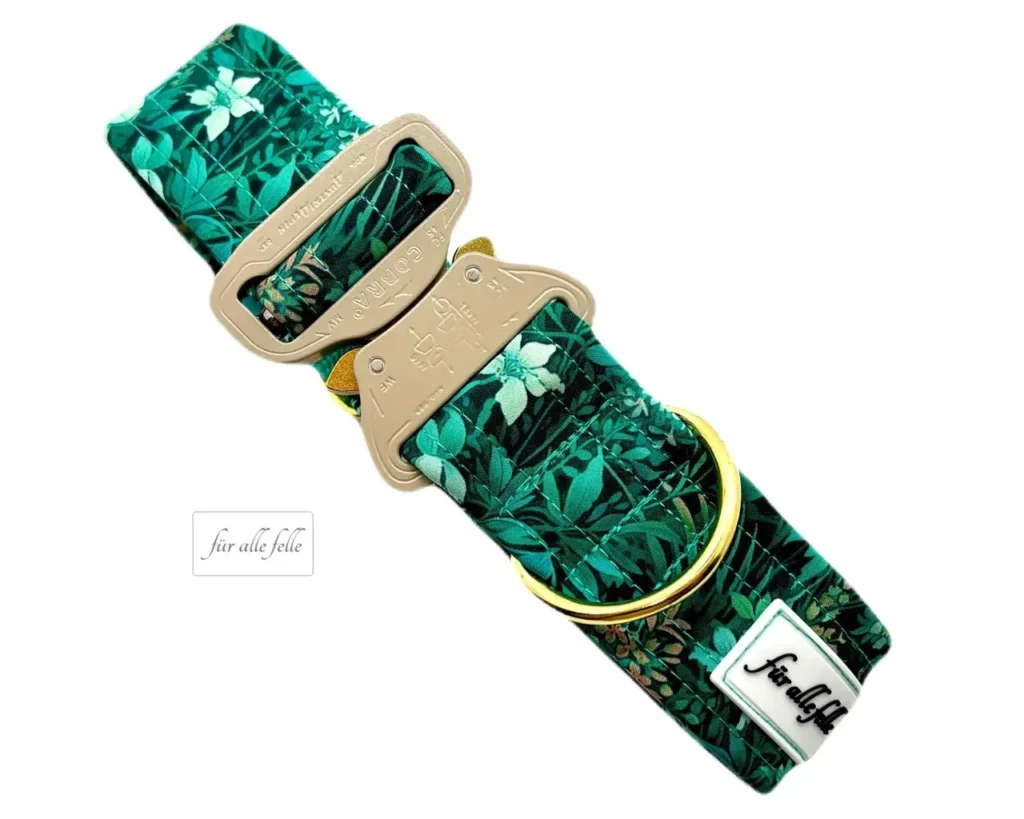 Edles Hundehalsband mit einem lebhaften Dschungel-Print in verschiedenen Grüntönen und einer goldfarbenen COBRA® Schnalle, akzentuiert mit einem 'Für alle Felle' Logo-Schild.