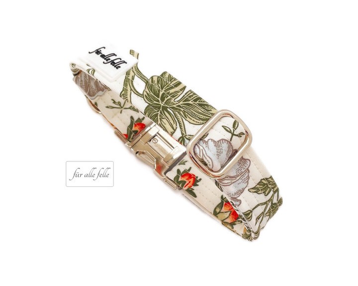 Handgefertigtes Hundehalsband mit botanischem Muster und silberner Schnalle, versehen mit dem charakteristischen 'Für alle Felle' Logo-Tag.