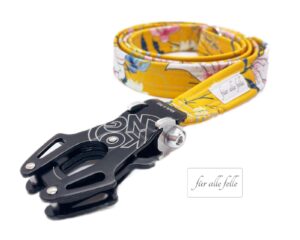 Handgefertigte 'Fiete ockergelb' Softshell-Hundeleine mit blumigem Design und Kong Frog® Karabiner, markiert mit 'Für alle Felle' Logo.