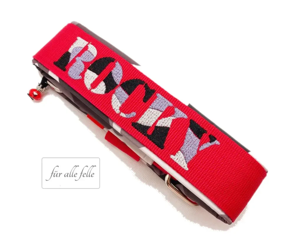Auffallendes breites Hundehalsband in Rot mit 'Rocky' in einem einzigartigen Camouflage-Design in Schwarz, Grau und Weiß, handgefertigt von 'Für alle Felle'.
